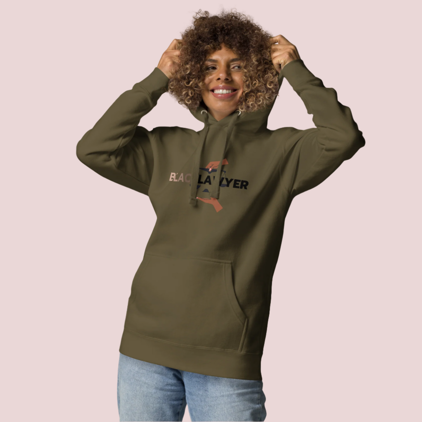 A model wearing jeans and an army green hoodie with the words "Black Lawyer" on it and a woman's hand holding an imbalanced justice scale.