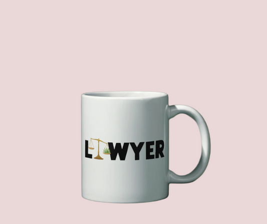 A white mug with the text "LAWYER", with the letter "A" stylized as a set of tilted justice scales, with one scale pan containing cannabis leaves while the other pan remains empty.