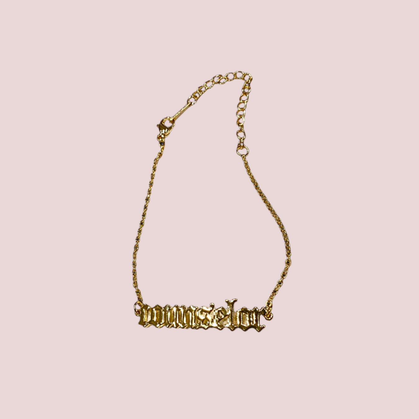 A gold chain bracelet featuring the word "counselor" in old English text.