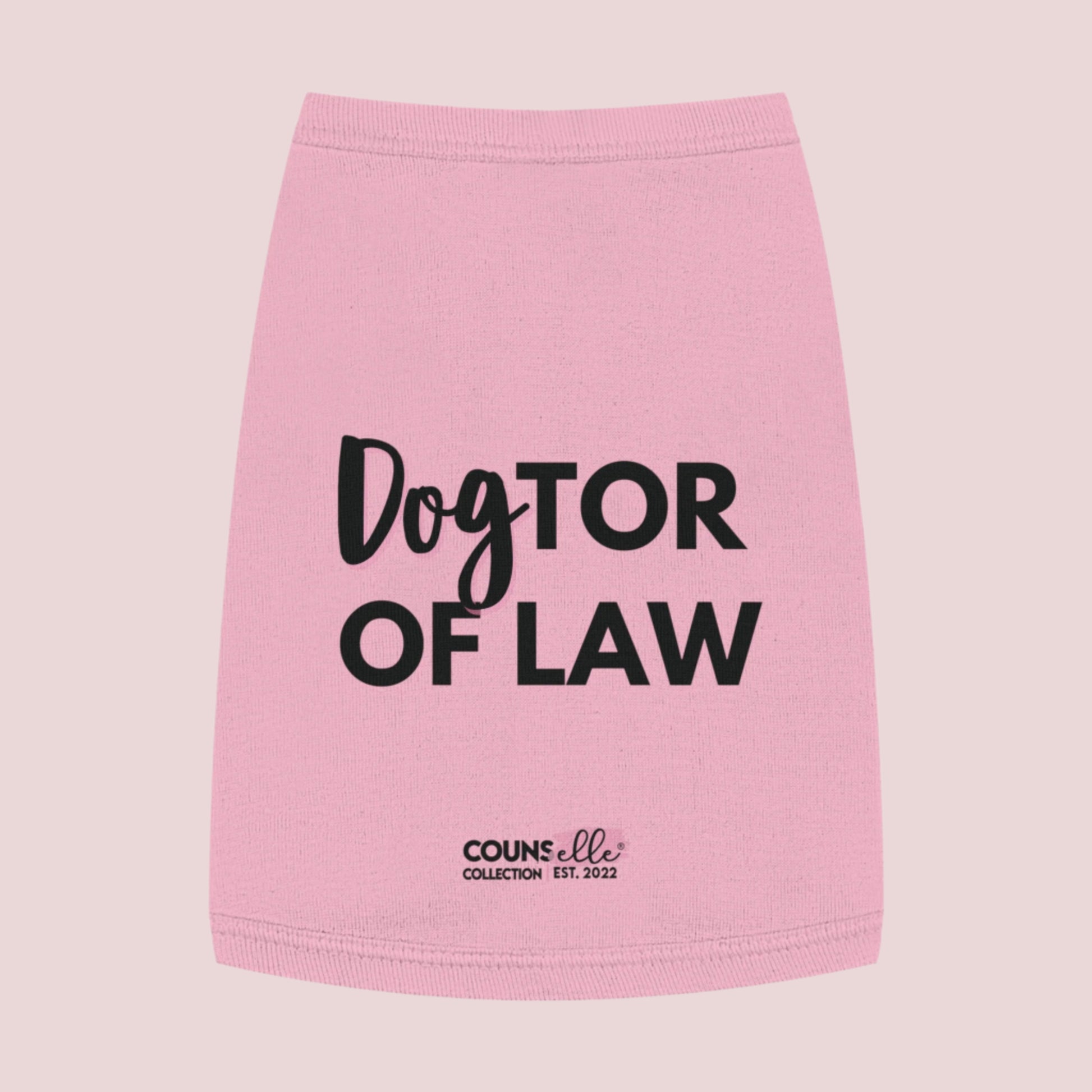 A pink pet tee  featuring the words "DogTOR OF LAW" and the counsellecollection logo near the hemline.