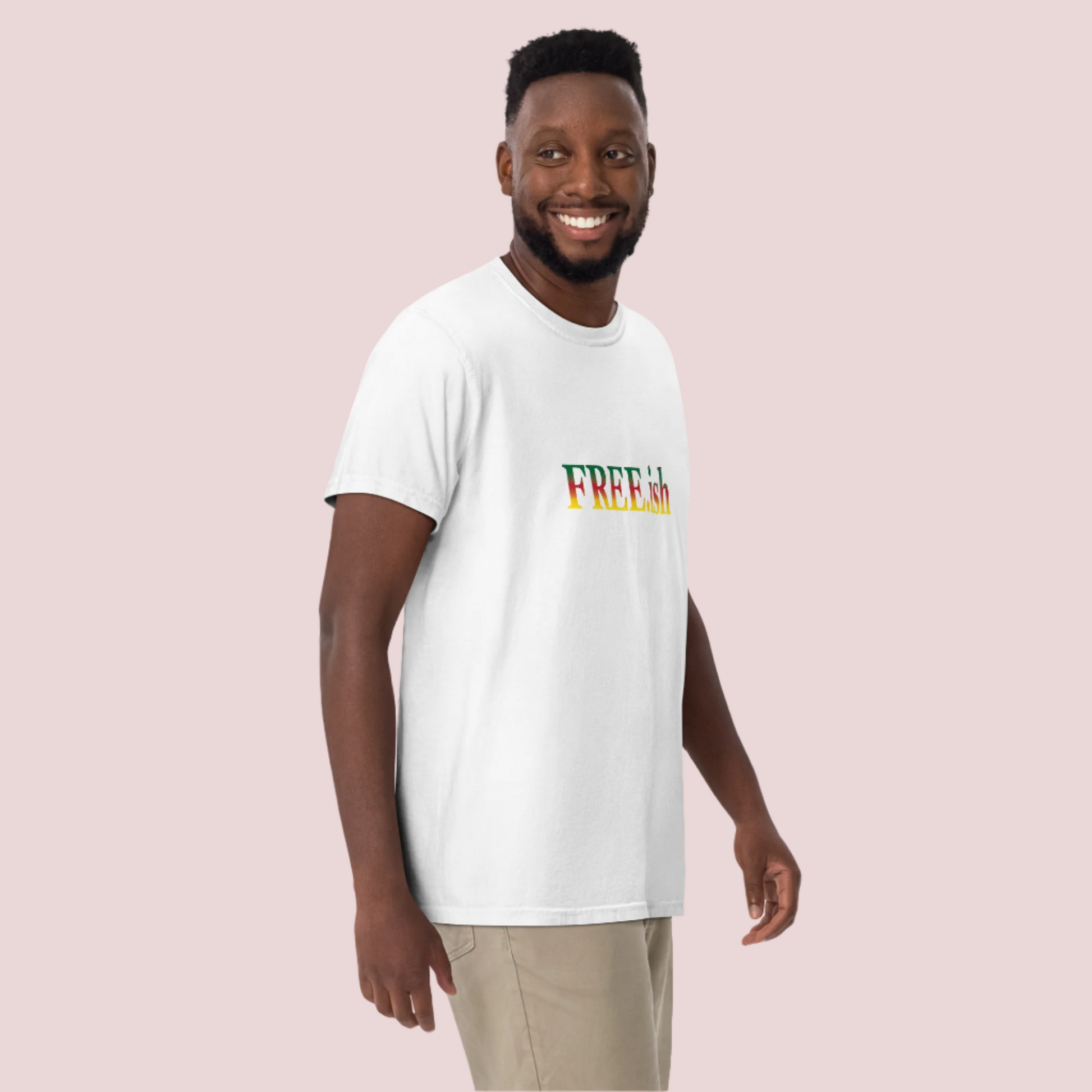 A person wearing a white roundneck tee featuring the text "FREE.ish" in green, red, and yellow striped font.