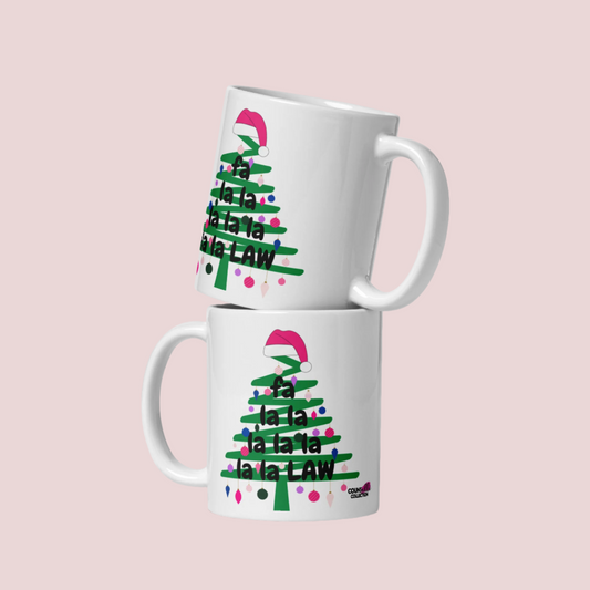 A white mug with an illustration of a  green Christmas tree doodle with lights and a Santa hat on top, and the text "Fa La La La Law", with the counsellecollection logo at the bottom right.