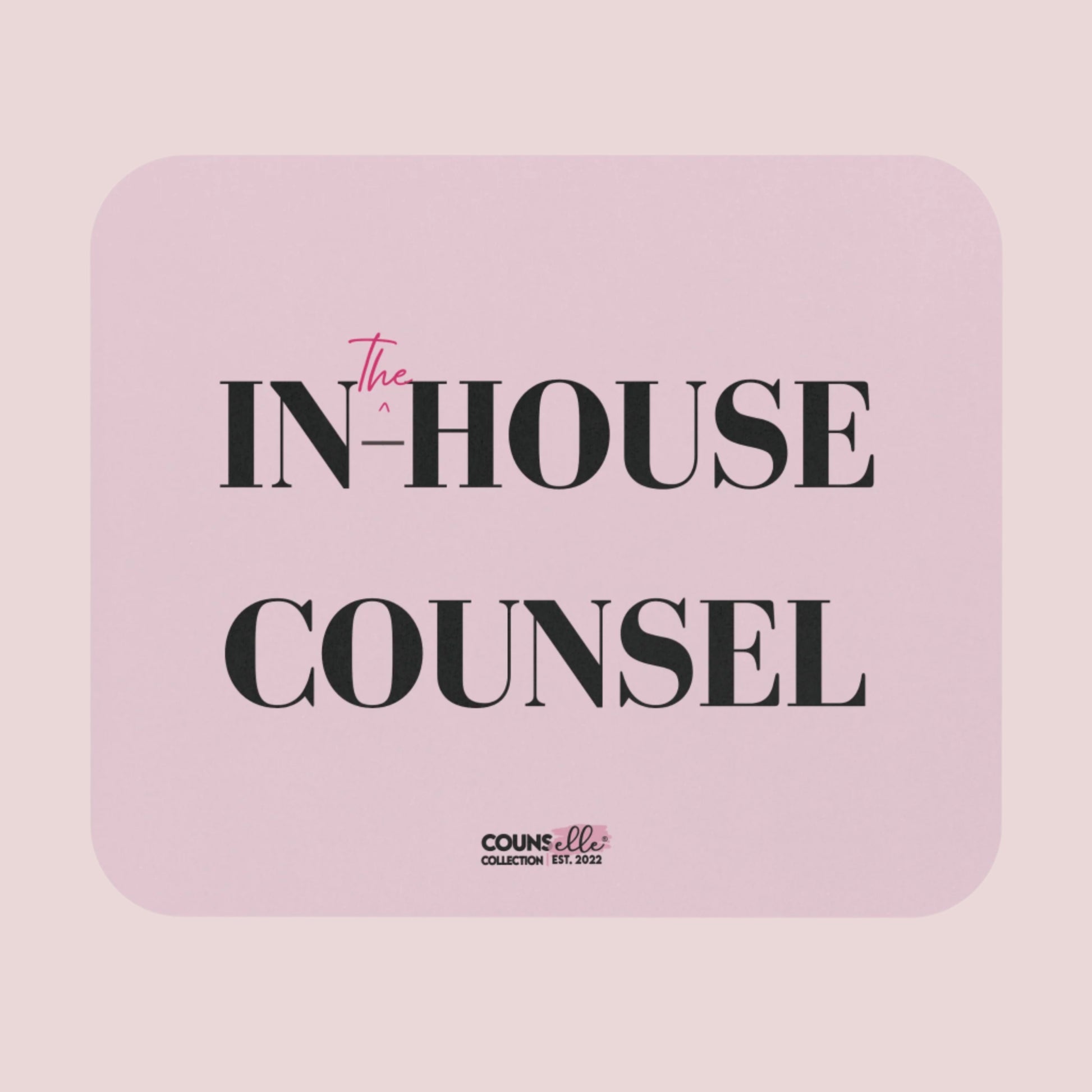 A rectangular, pink mousepad showing the text "IN", "^", "the", "-HOUSE", and COUNSEL", with the counsellecollection logo at the bottom of the design.