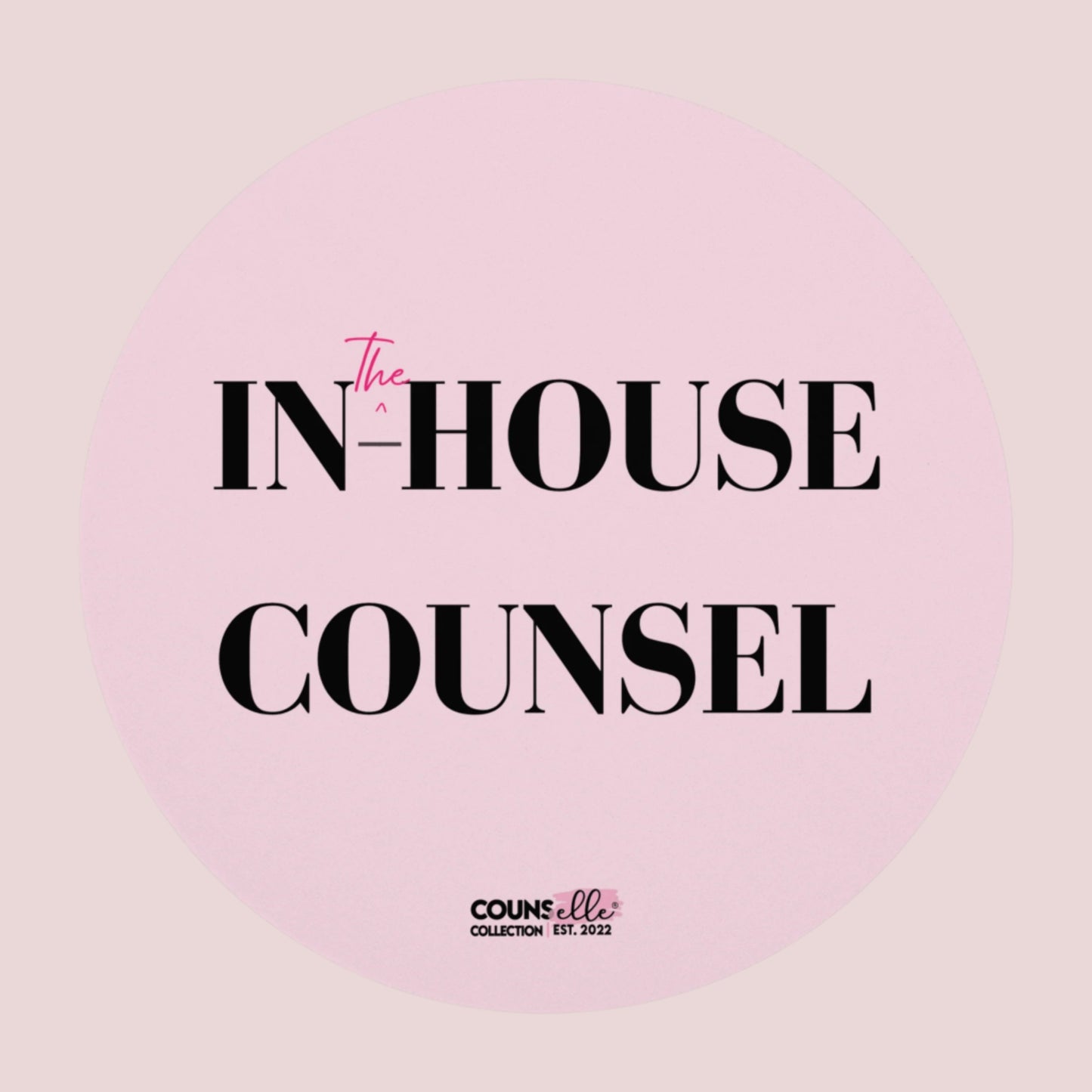 A round, pink mouse pad showing the text "IN", "^", "the", "-HOUSE", and COUNSEL", with the counsellecollection logo at the bottom of the design.