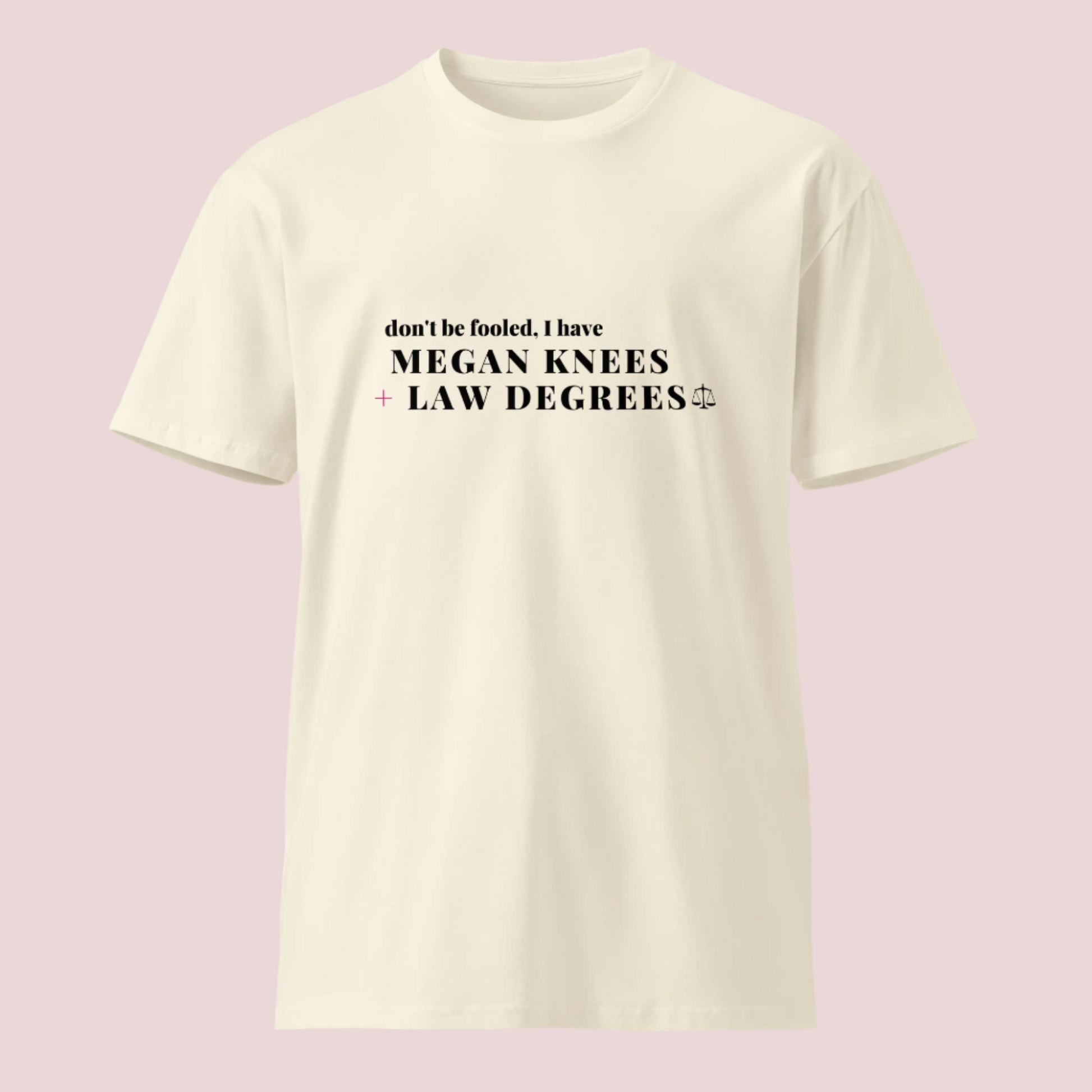 A cream roundneck tee featuring the text: "DON'T BE FOOLED, I'VE GOT MEGAN KNEES + LAW DEGREES