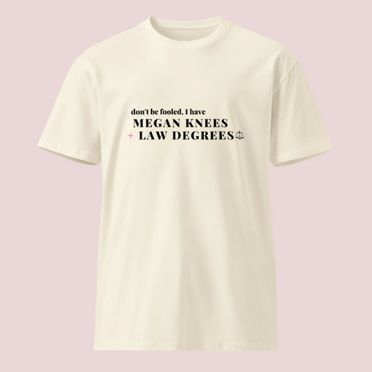 A cream roundneck tee featuring the text: "DON'T BE FOOLED, I'VE GOT MEGAN KNEES + LAW DEGREES
