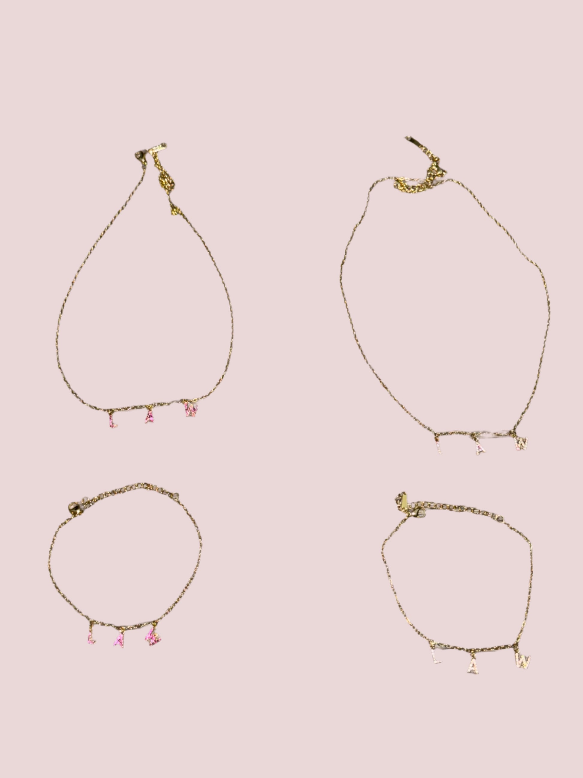 Two necklaces and two bracelets with the word "LAW" in hot pink and classic stones as charms.