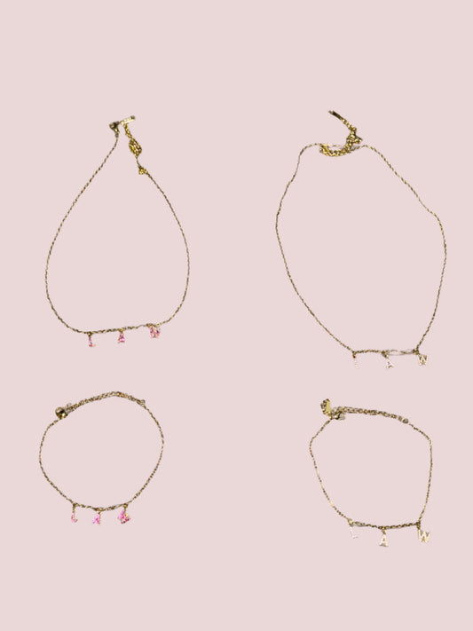 Two necklaces and two bracelets with the word "LAW" in hot pink and classic stones as charms.