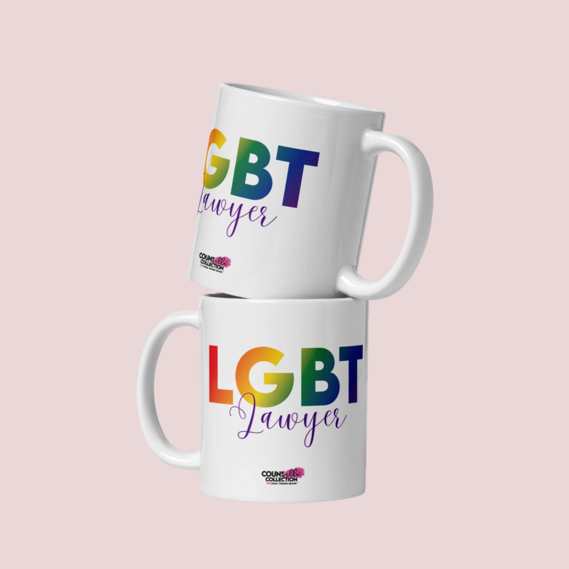 Two white mugs stacked on top of one another, featuring the text "LGBT" in a rainbow-colored font, "Lawyer" in purple script, and the counsellecollection logo at the bottom  of the design.