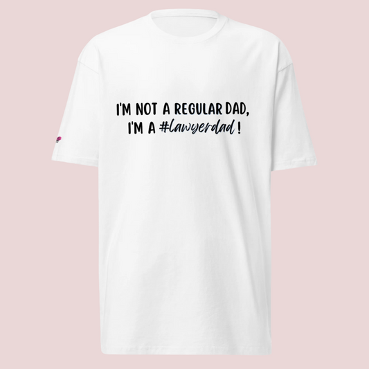 A white roundneck tee with the text "I'm not a regular dad, I'm a #lawyerdad!"  and the counsellecollection logo on the sleeve.