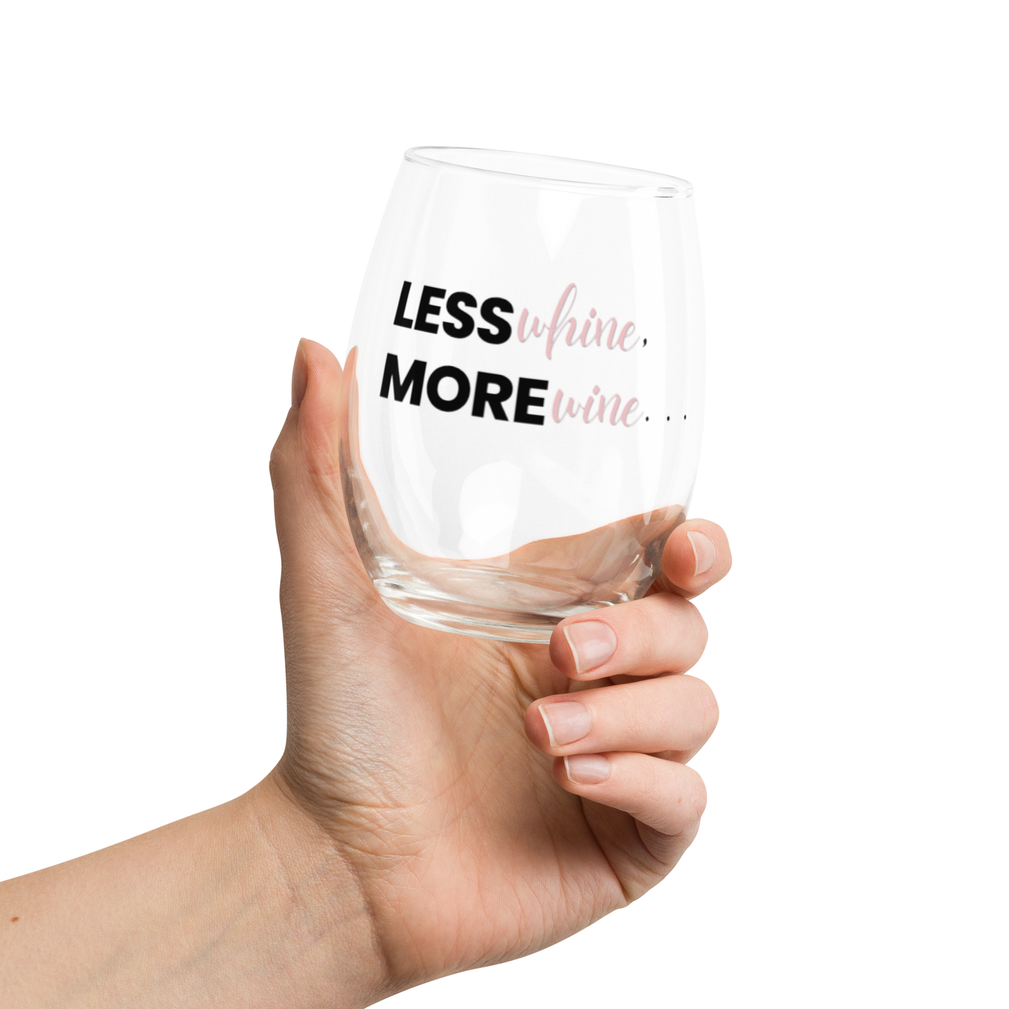 A hand holding a clear, stemless wine glass with the words "Less WHINE, More WINE" written on it