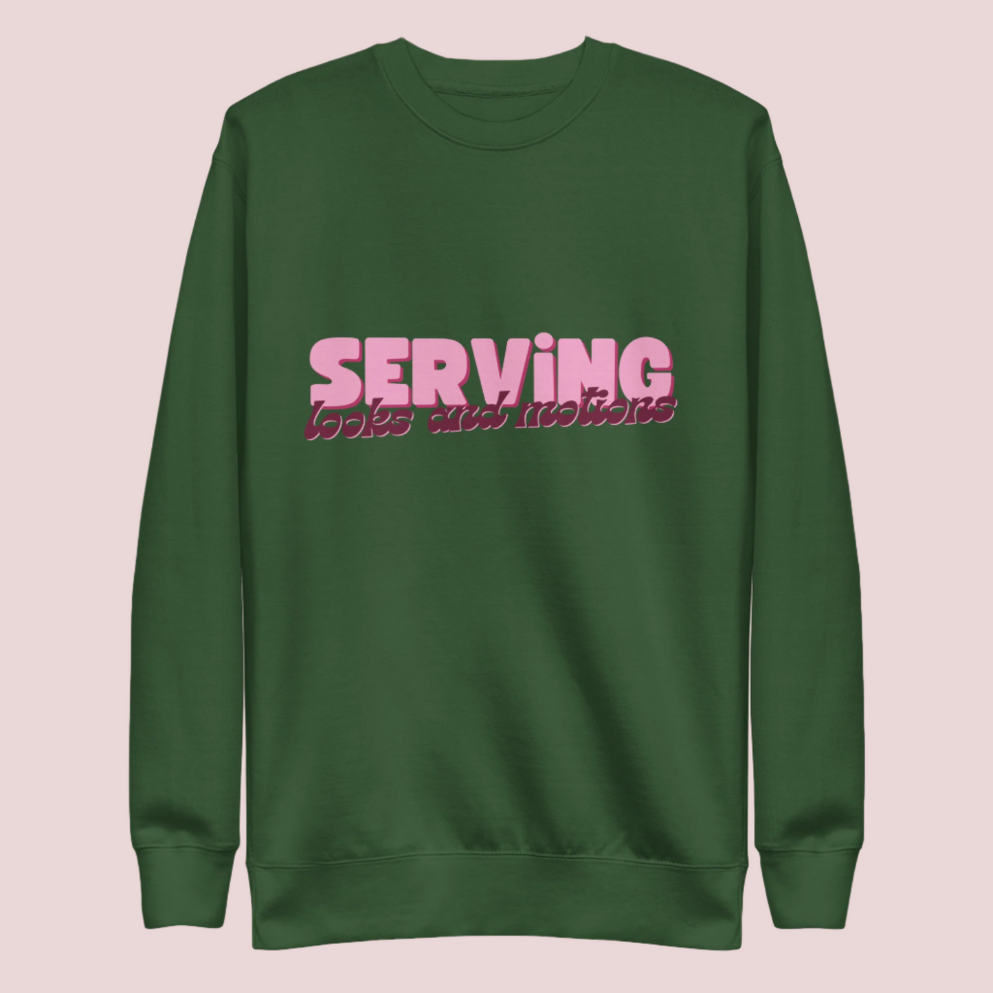 A forest green sweatshirt showing the text "SERVING looks and motions" in pink font.