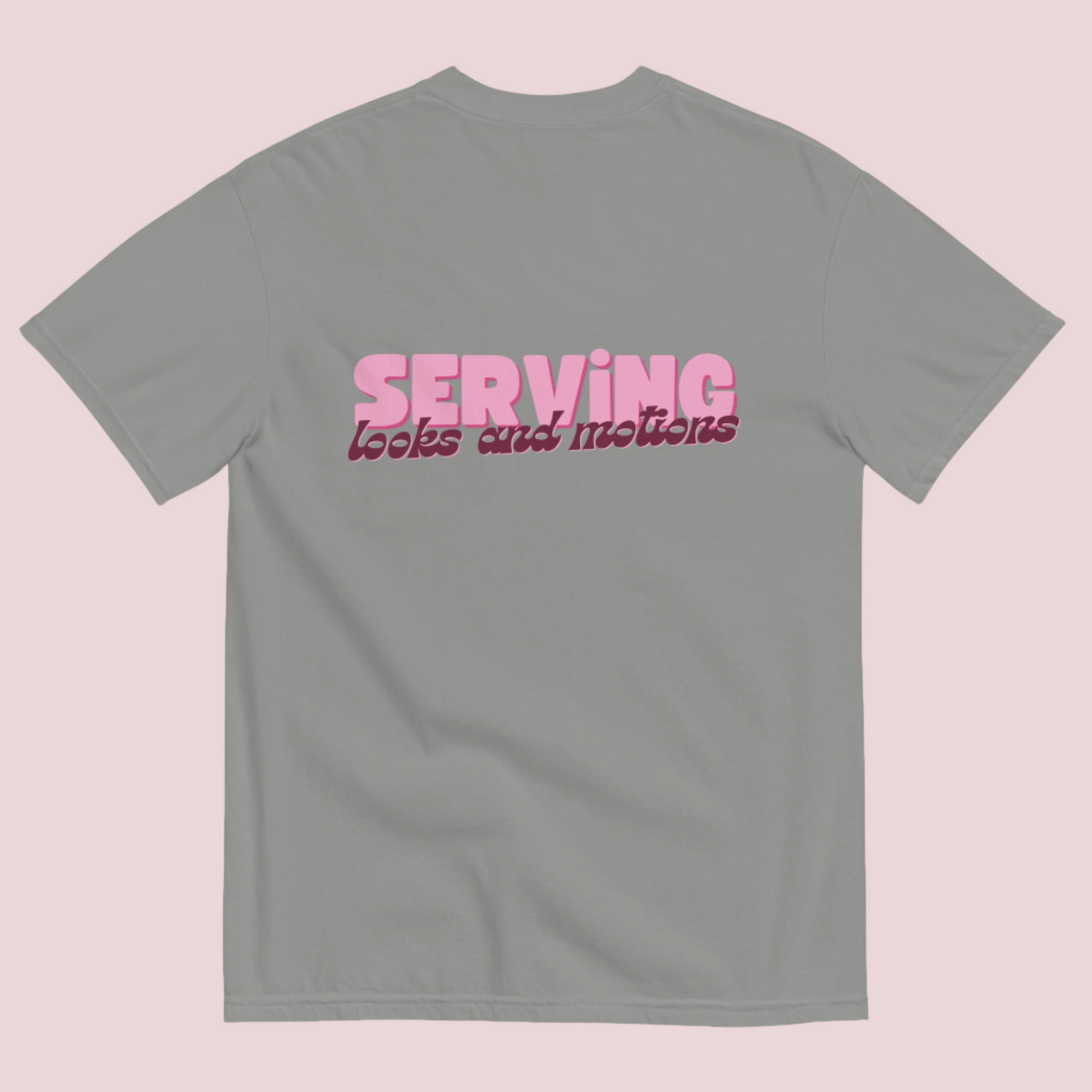 A grey roundneck tee showing the text "SERVING looks and motions" in pink font.
