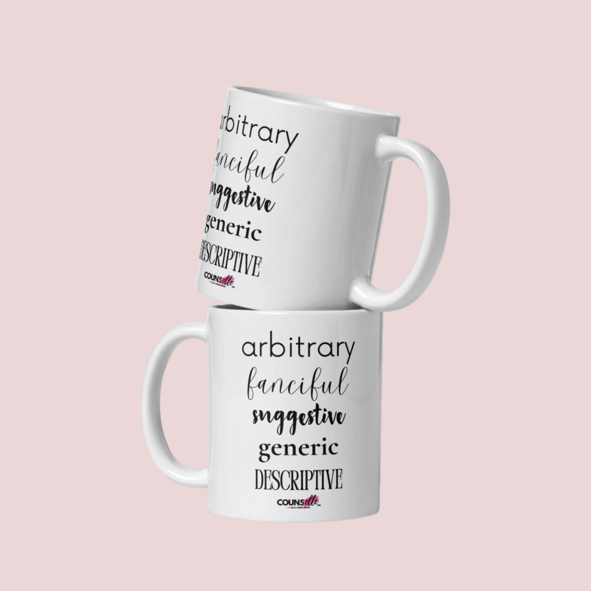 Two white mugs stacked together, each featuring the words "arbitrary", "fanciful", "suggestive", "generic", and "descriptive" in different font styles, with the counsellecollection logo at the bottom