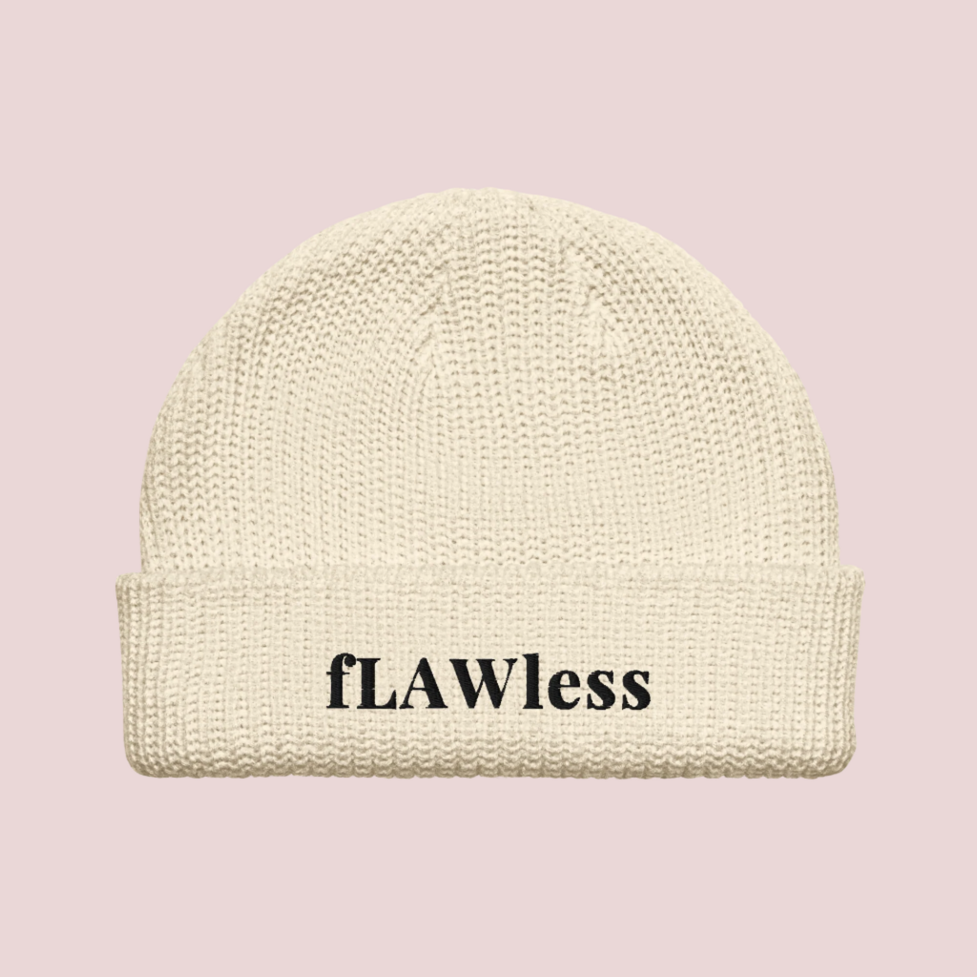 A cream beanie with the text "fLAWless" in black text written on it.