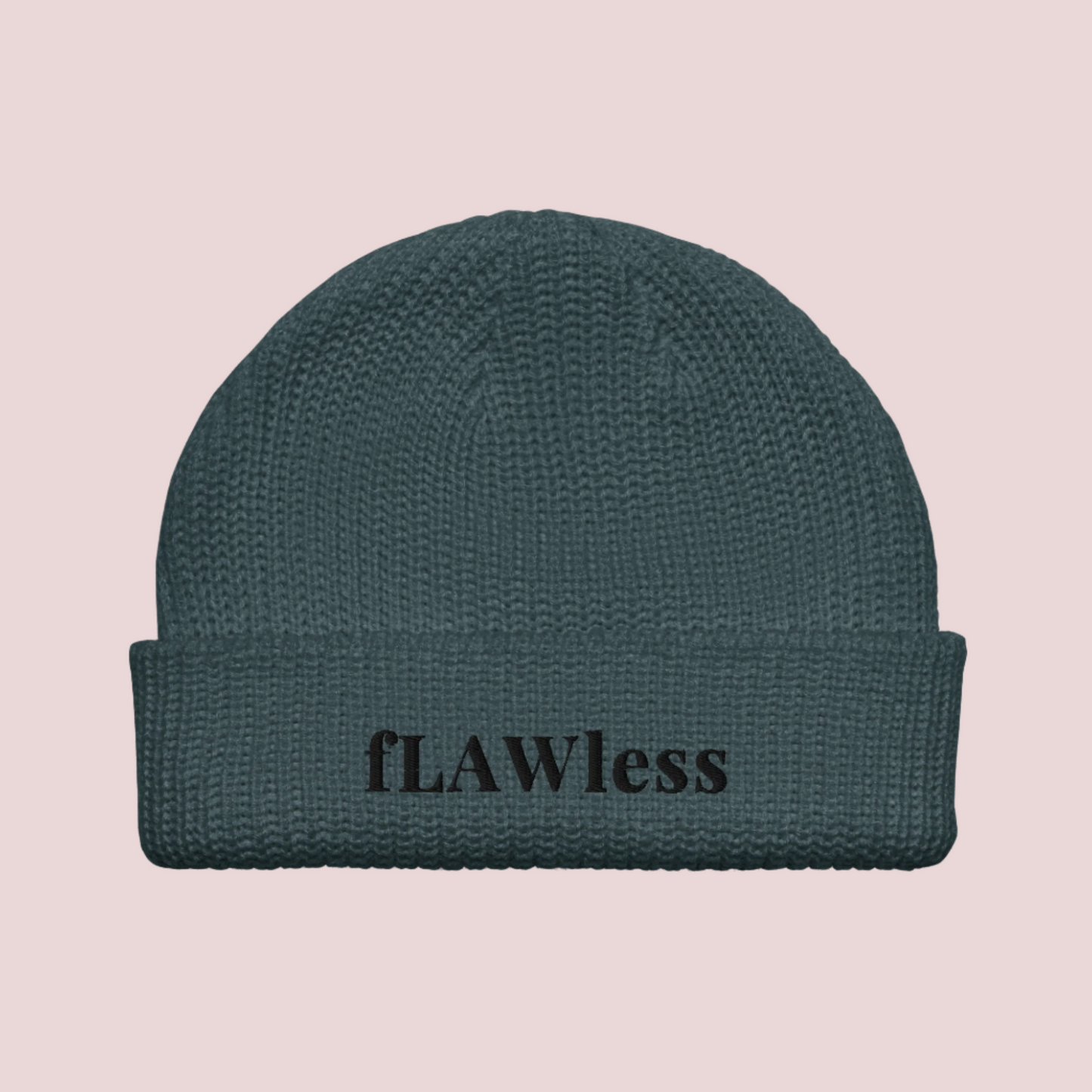 A peacock blue beanie with the text "fLAWless" in black text written on it.