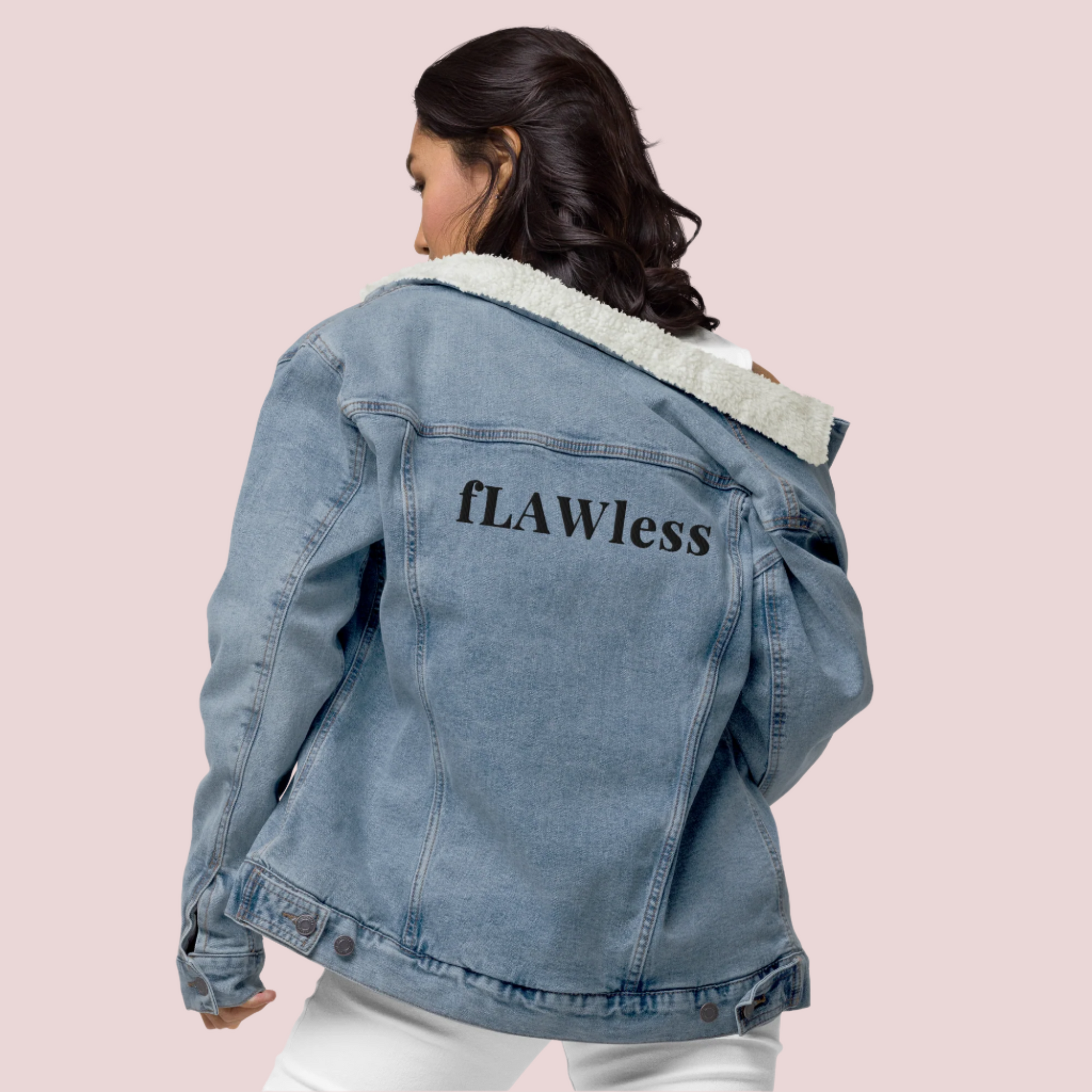 A model wearing a white shirt, pants, and a denim jacket with a soft sherpa lining, showing the text "fLAWless" at the back.