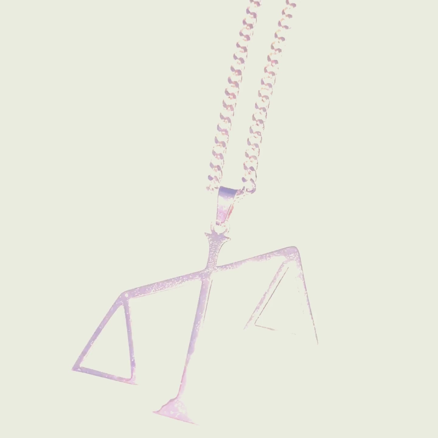 A gold chain necklace featuring a pendant in the shape of the scales of justice tipped to one side.