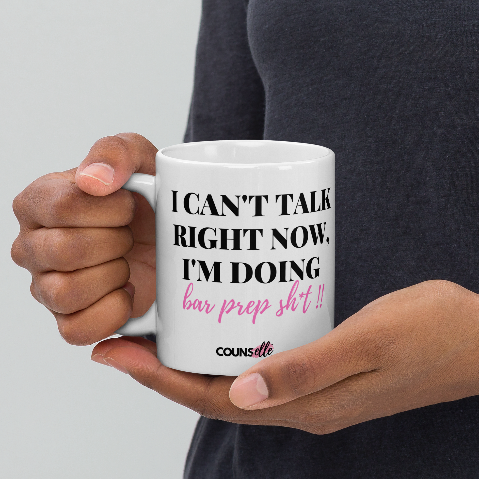 A person holding a white mug showing the text "I CAN'T TALK RIGHT NOW, I'M DOING BAR PREP SH*T!", with the counsellecollection logo at the bottom of the text.
