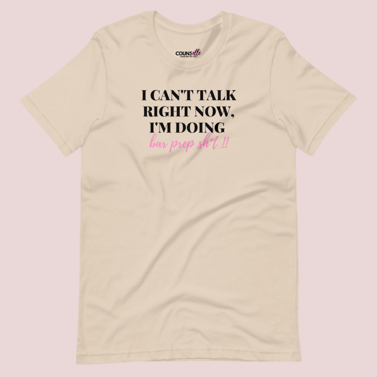 A cream roundneck tee showing the text "I CAN'T TALK RIGHT NOW, I'M DOING BAR PREP SH*T!"