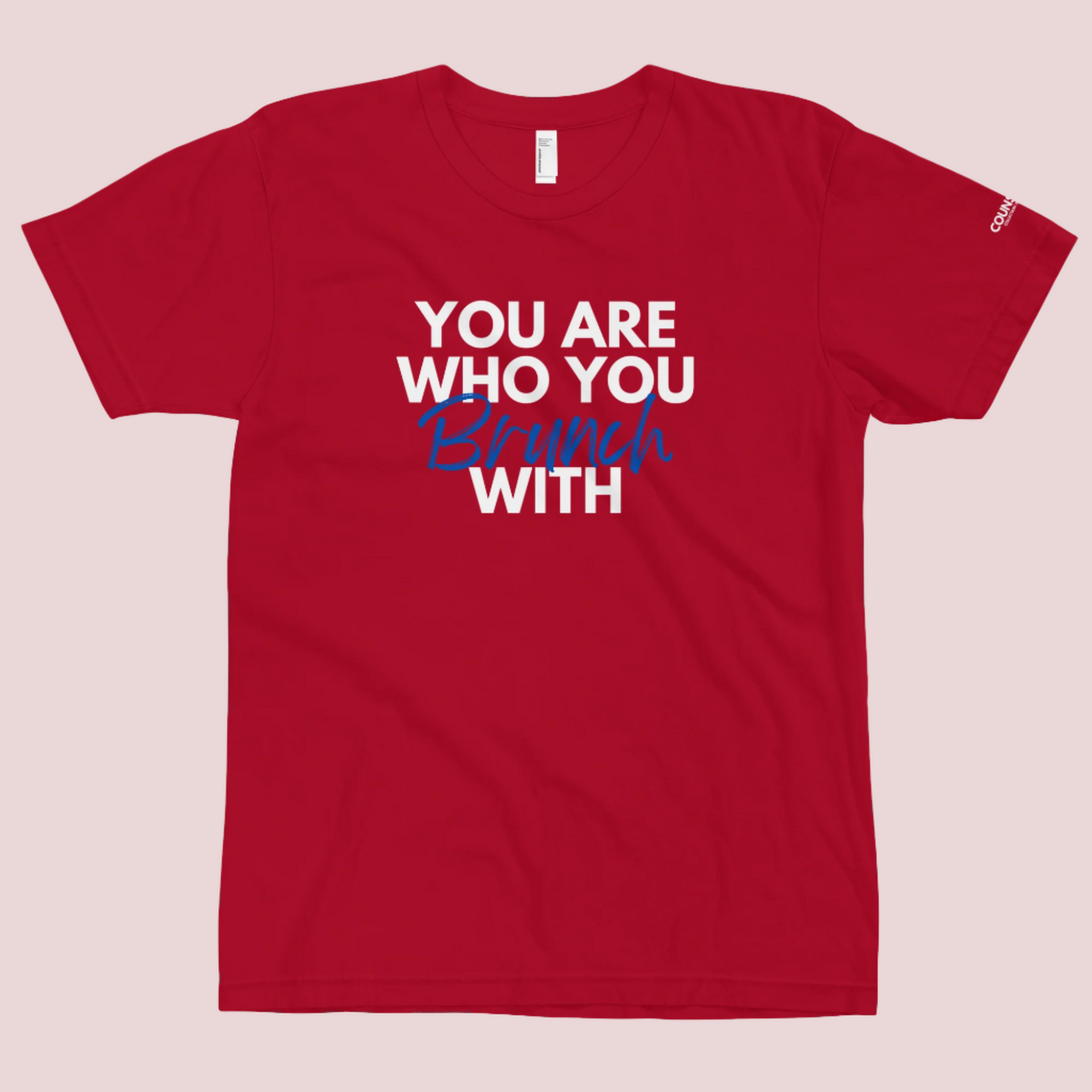 A red round neck short sleeved shirt featuring the slogan "You are who you brunch with" in front and the counsellecollection logo on the left sleeve.
