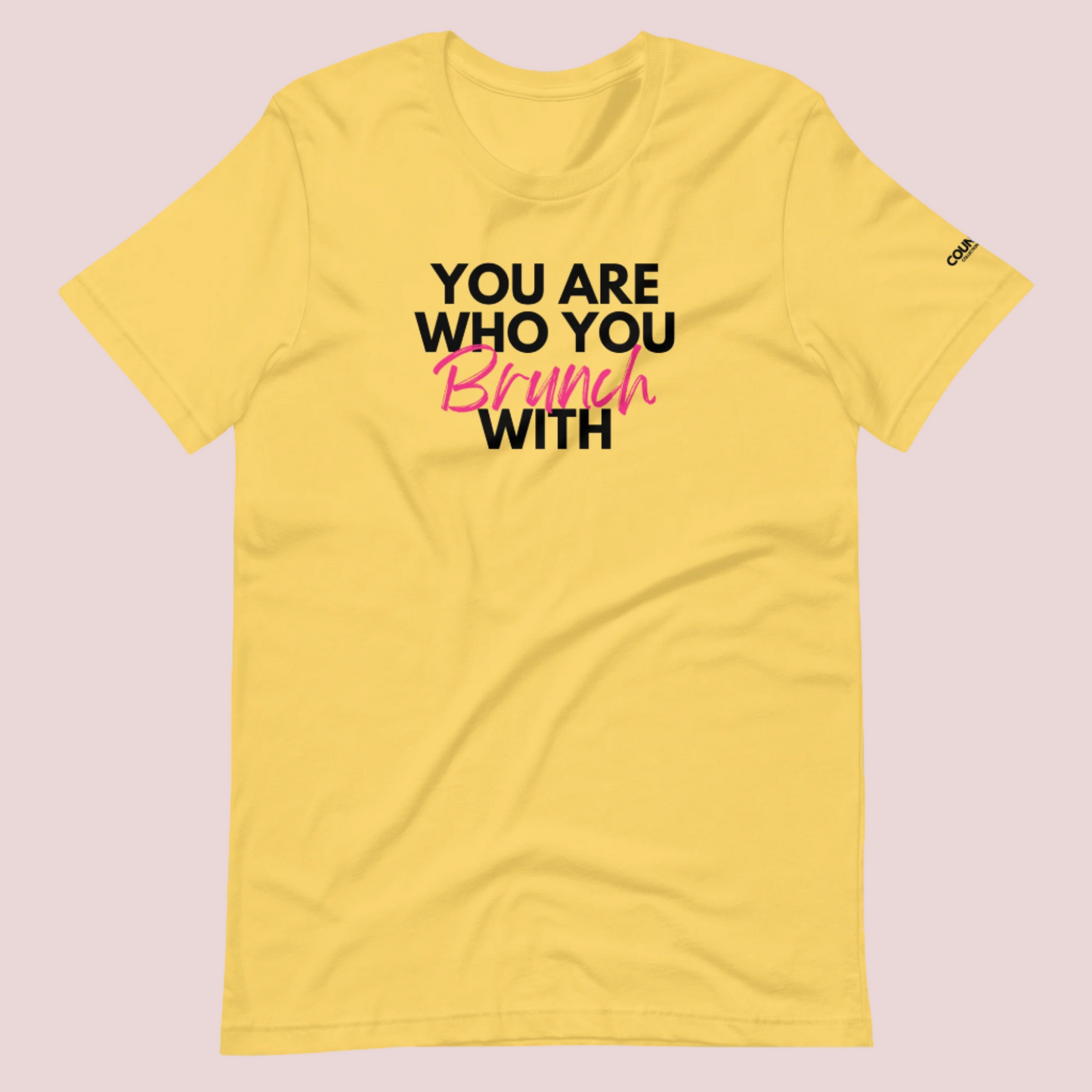 A yellow round neck short sleeved shirt featuring the slogan "You are who you brunch with" in front and the counsellecollection logo on the left sleeve.