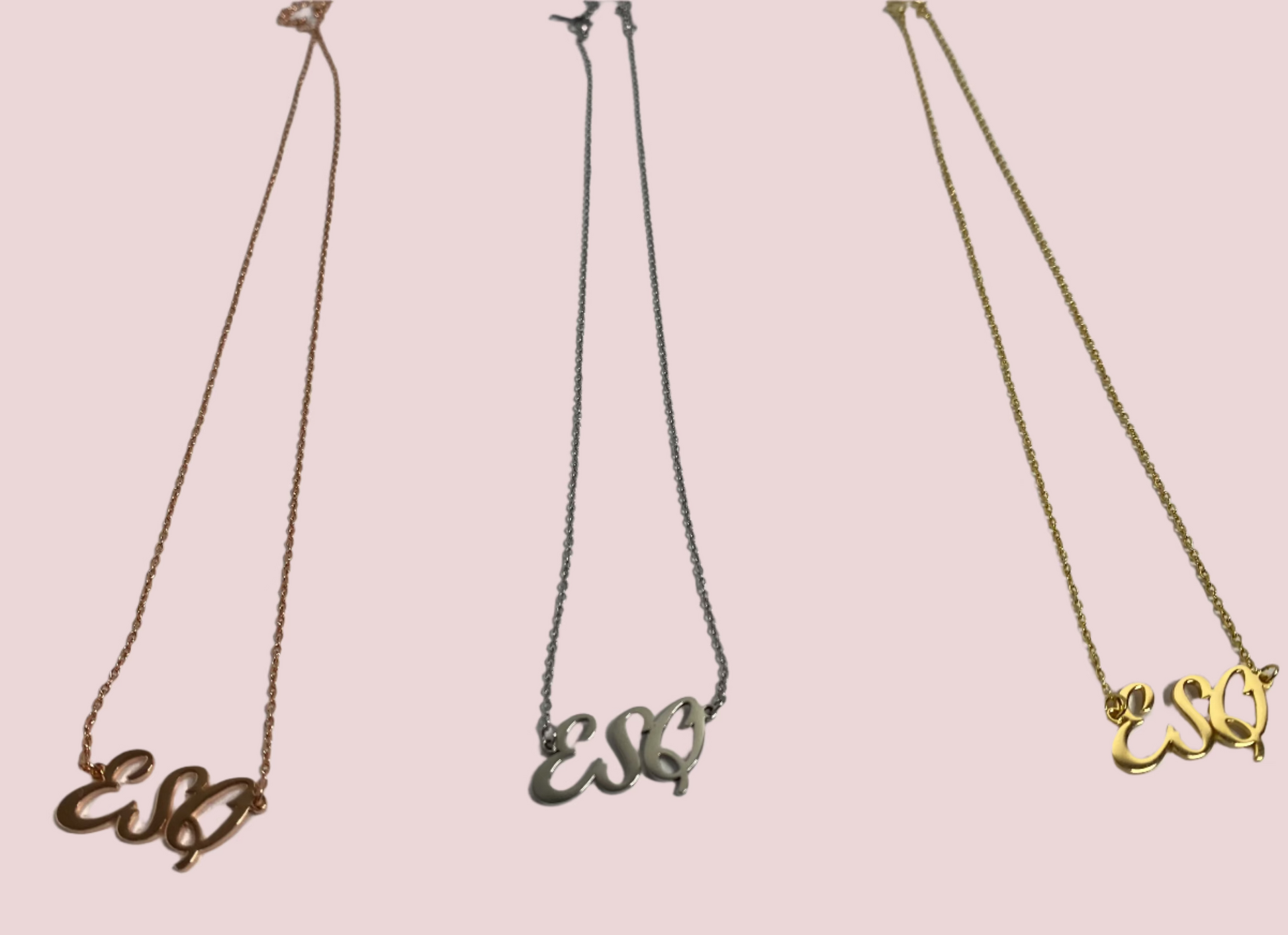 A necklace featuring the letters "ESQ" in an elegant script font as a charm on a delicate chain. Available in Gold, Rose Gold, and Silver, with chain lengths of 18" or 20".