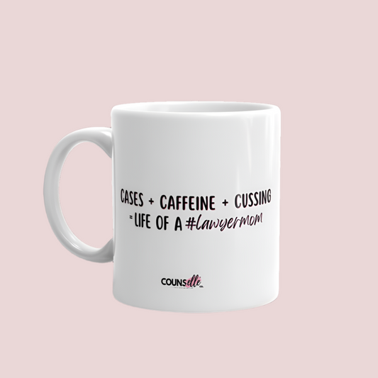 A white mug with the text "Cases + Caffeine + Cussing = LIFE OF A #lawyermom", and the counsellecollection logo at the bottom of the design