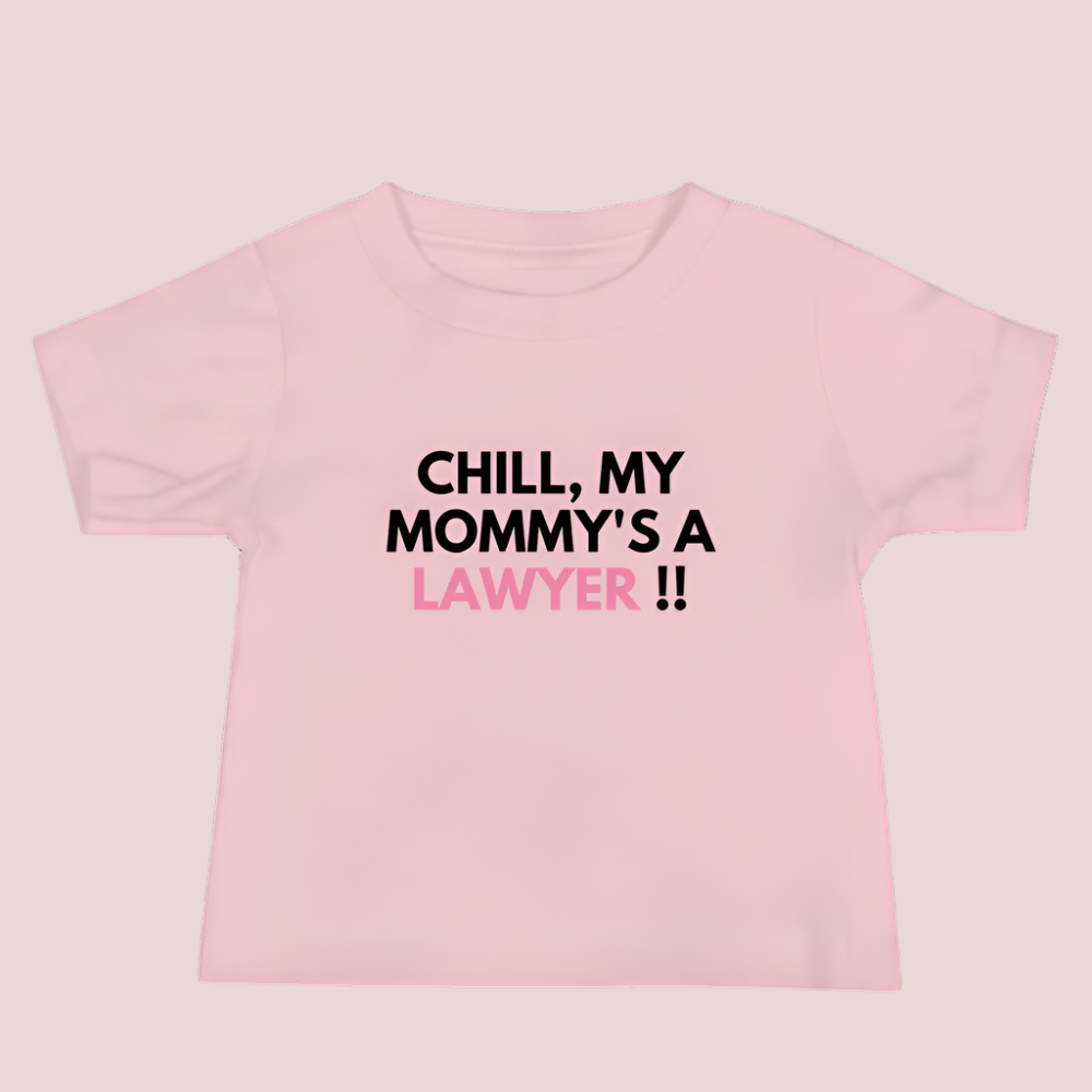 A pink roundneck kid's tee featuring the quote "Chill my mommy's a lawyer" in uppercase text.