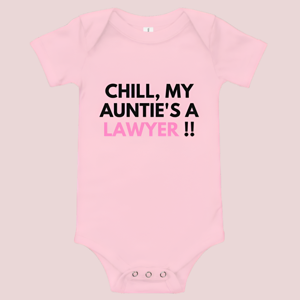 A pink baby onesie with a three-snap leg closure featuring the quote "Chill my auntie's a lawyer" in uppercase block text.
