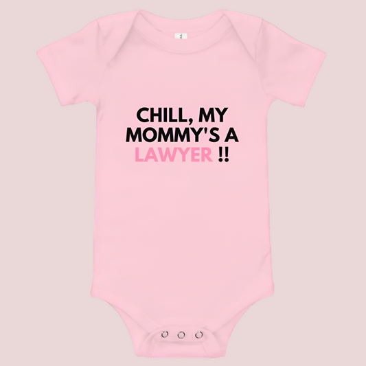 A pink baby onesie with a three-snap leg closure featuring the quote "Chill my mommy's a lawyer" in uppercase block text.
