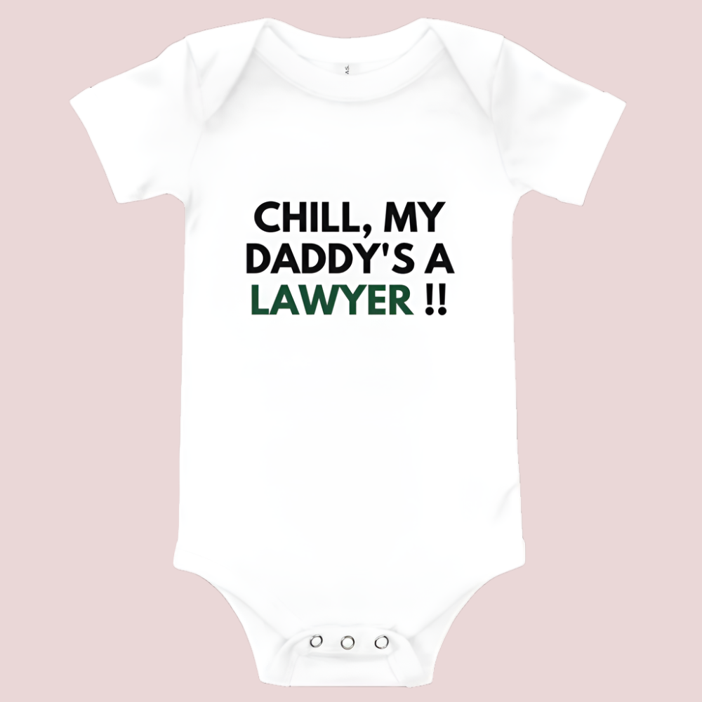 A white baby onesie with a three-snap leg closure featuring the quote "Chill my daddy's a lawyer" in uppercase block text.