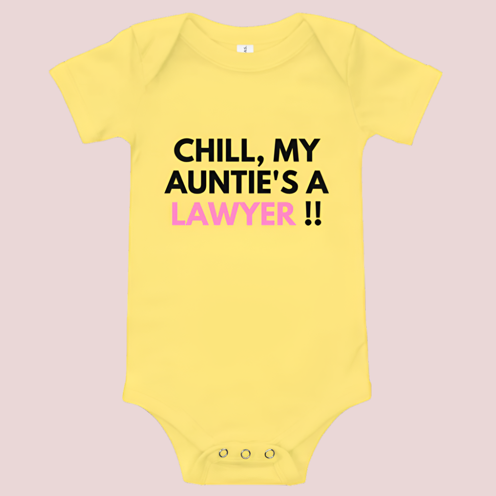 A yellow baby onesie with a three-snap leg closure featuring the quote "Chill my auntie's a lawyer" in uppercase block text.