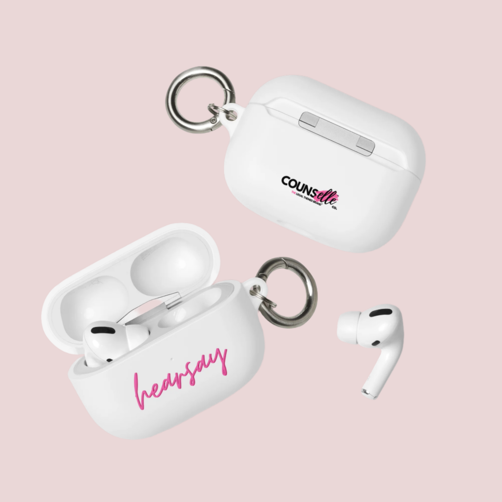 Two white AirPods Cases showing the word "hearsay" in script font on one of the cases and the counsellecollection logo on the other. A single airpod can also be seen beside one of the cases.