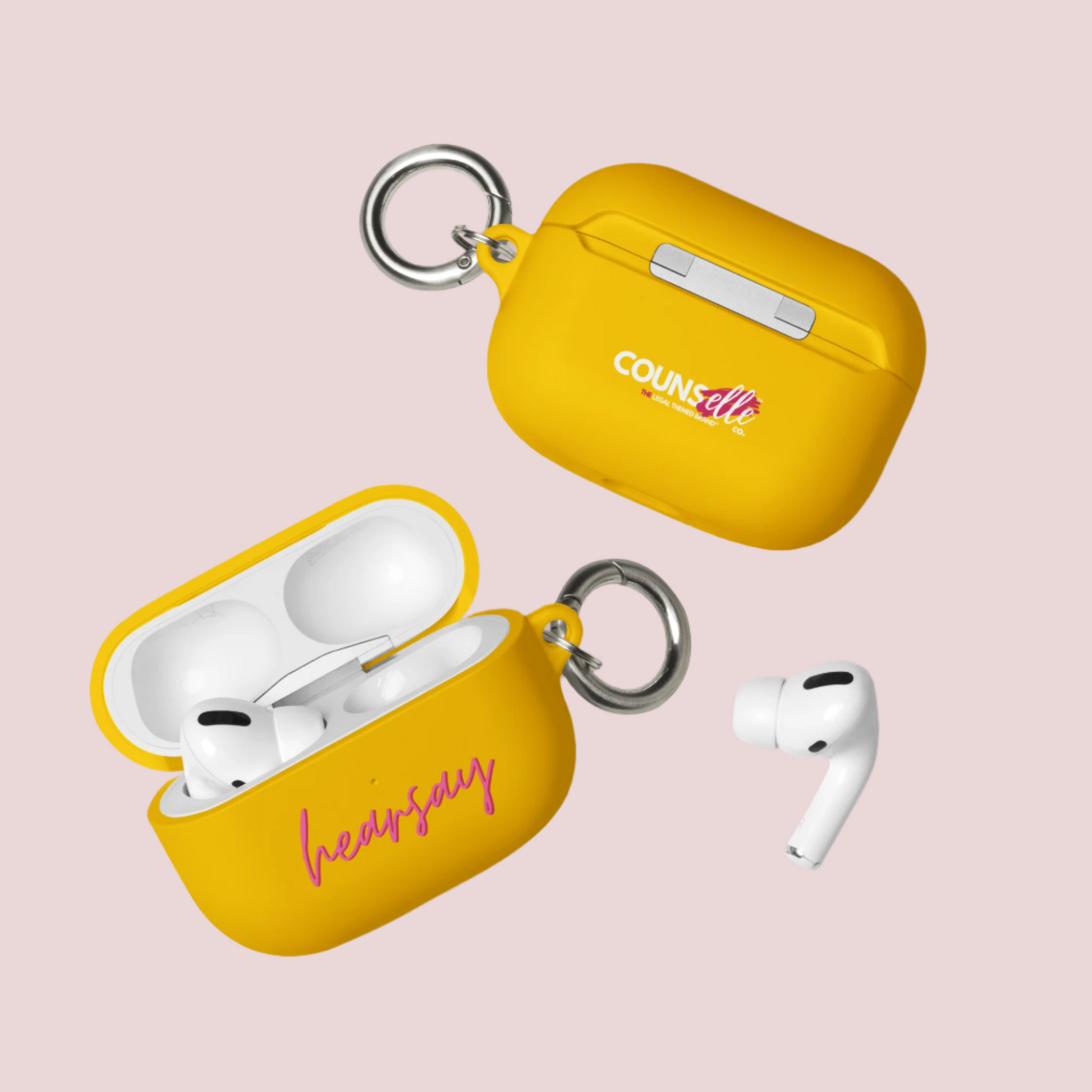 Two yellow AirPods Cases showing the word "hearsay" in script font on one of the cases and the counsellecollection logo on the other. A single airpod can also be seen beside one of the cases.