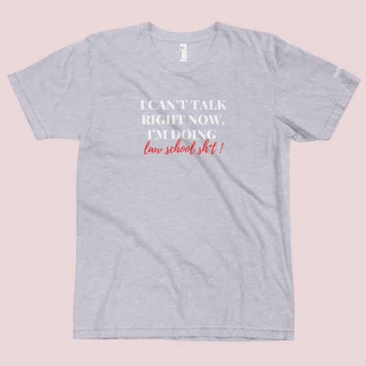 A grey roundneck tee showing the text "I CAN'T TALK RIGHT NOW, I'M DOING LAW SCHOOL SH*T!", with the counsellecollection logo shown on a sleeve