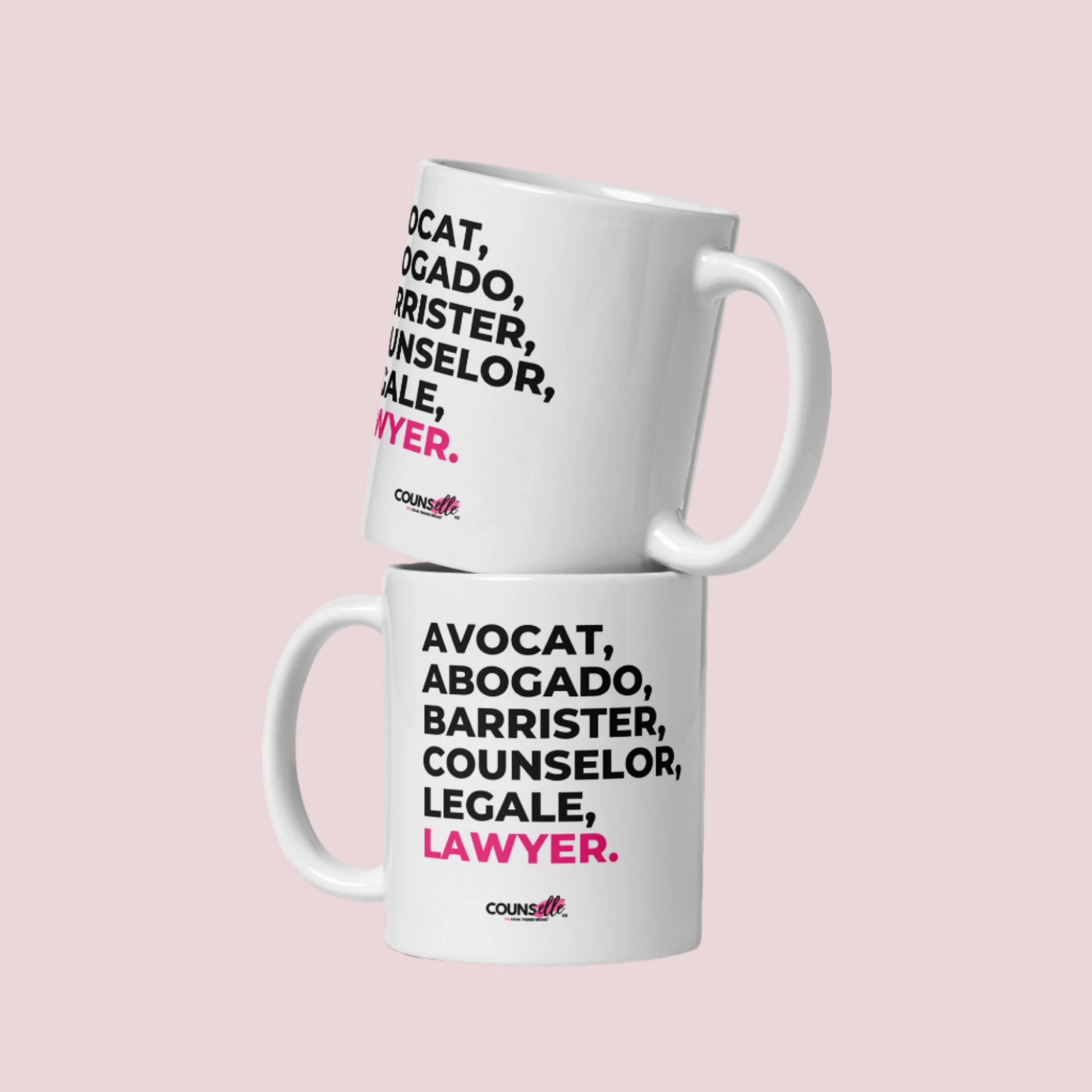 Two white mugs with the text "avocat", "abogado", "barrister", "counselor", "legale", and "lawyer" on the front. Mugs are stacked on top of one another. Counselle Collection® logo under text.