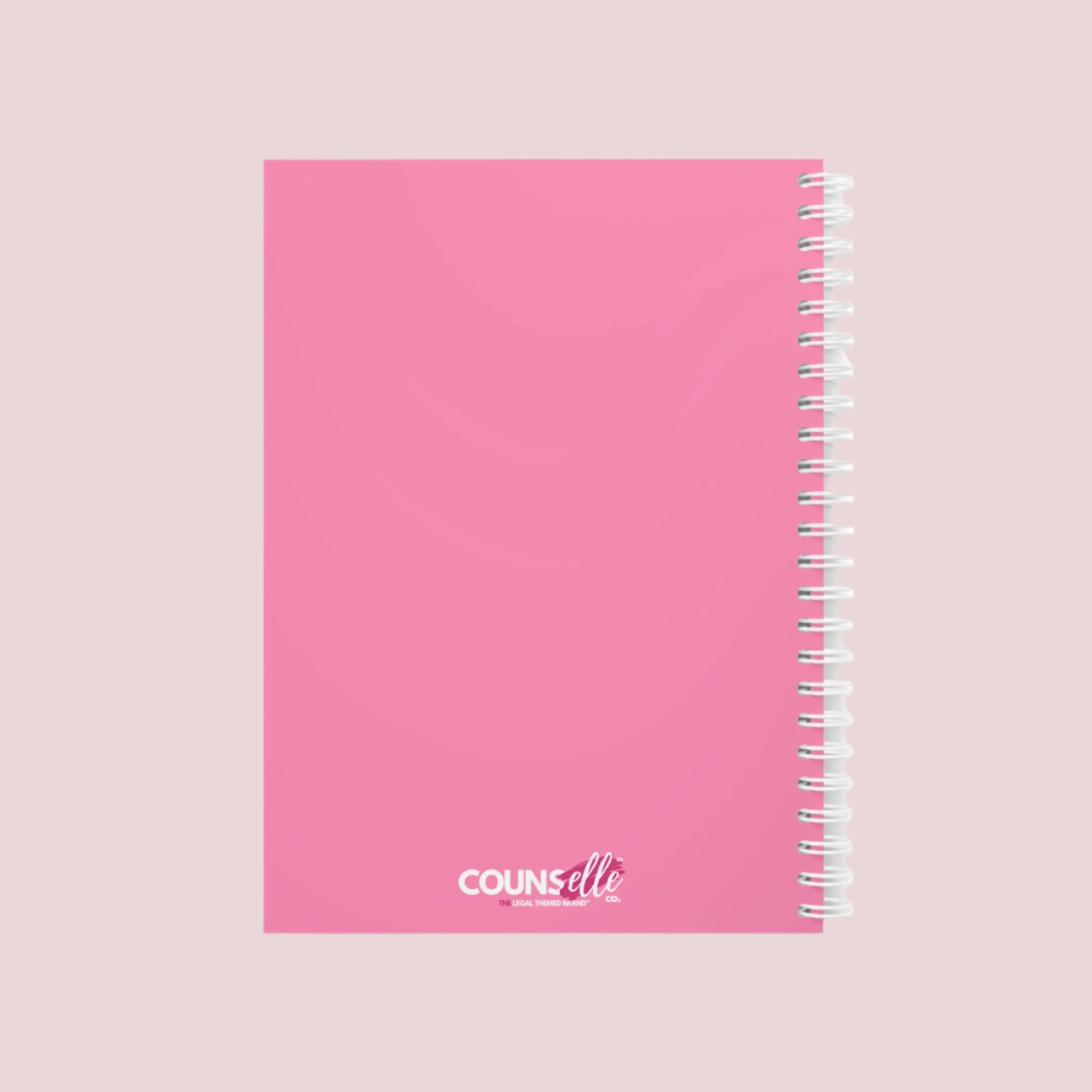 A pink notebook with the phrase "I can’t talk right now, I’m doing Lawyer sh*t" on the cover and the counselle collection logo on the back cover. . Ring-bound with ruled pages.