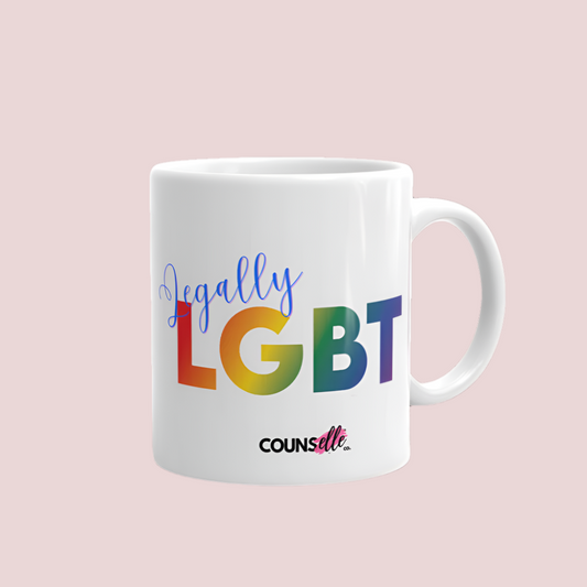A white mug featuring the text "LGBT" in a rainbow-colored font, "Lawyer" in blue script, and the counsellecollection logo at the bottom  of the design.