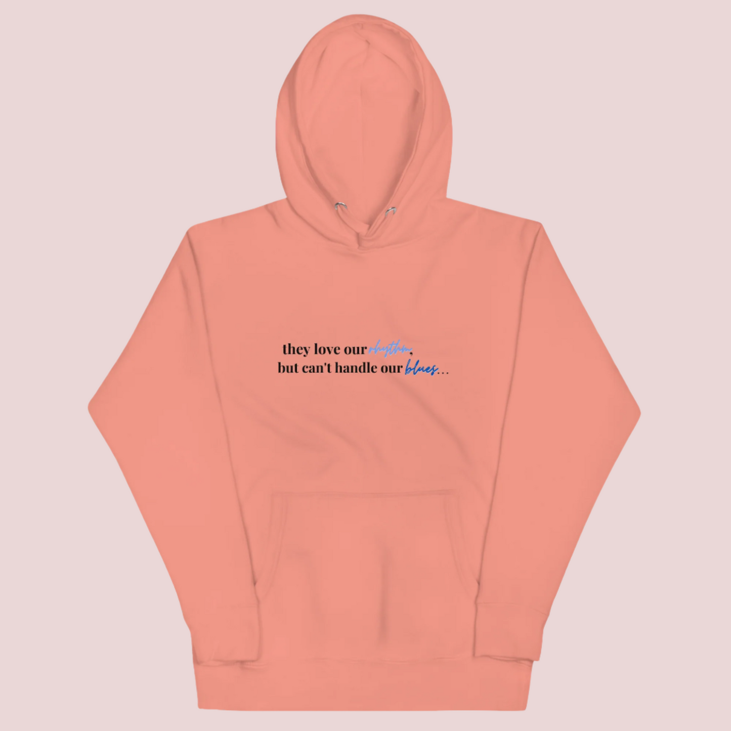 A peach crewneck long-sleeved hoodie with the text "they love our rhythm but can't handle our blues"