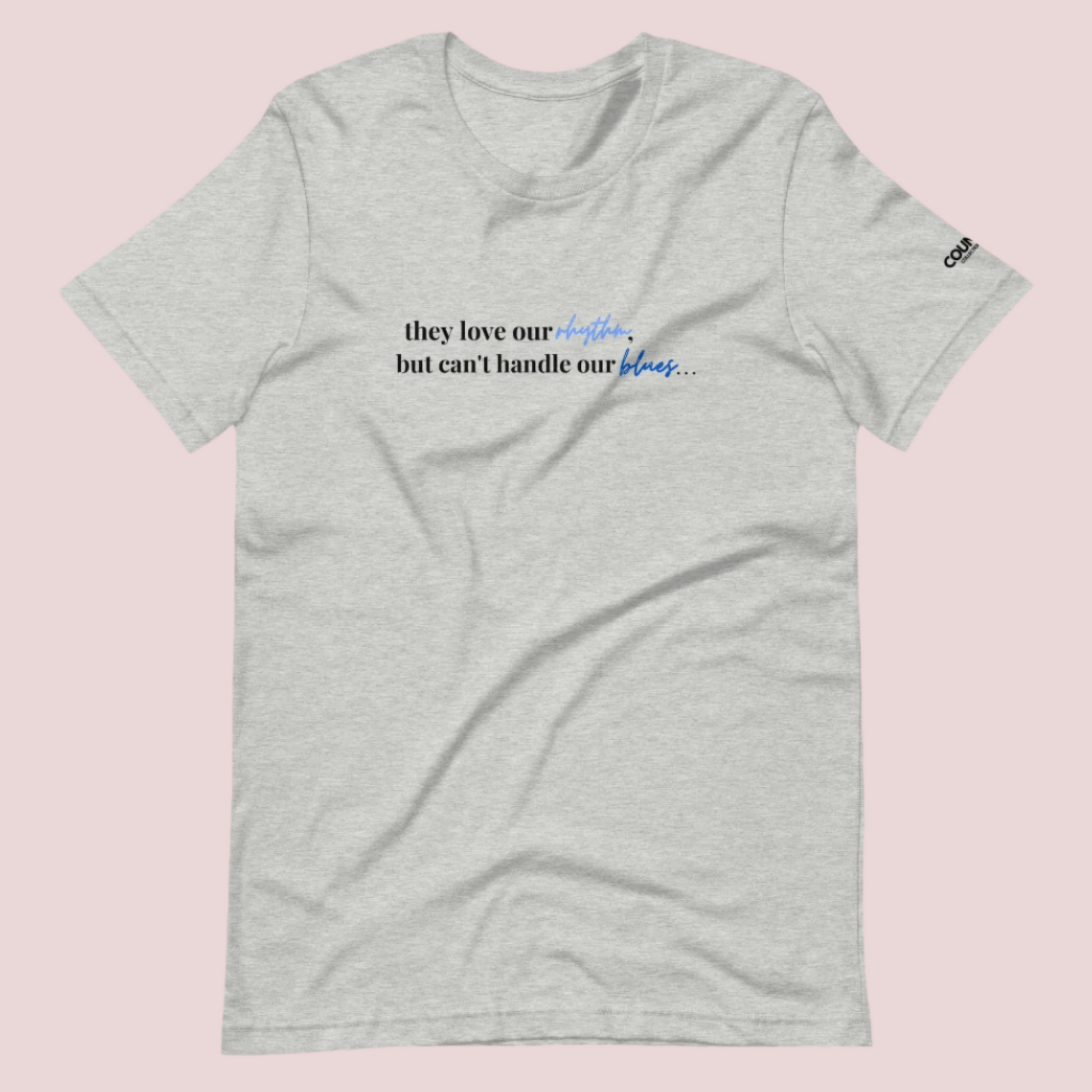 A heather grey t-shirt with the text "They love our rhythm, but they can't handle our blues" on the front.