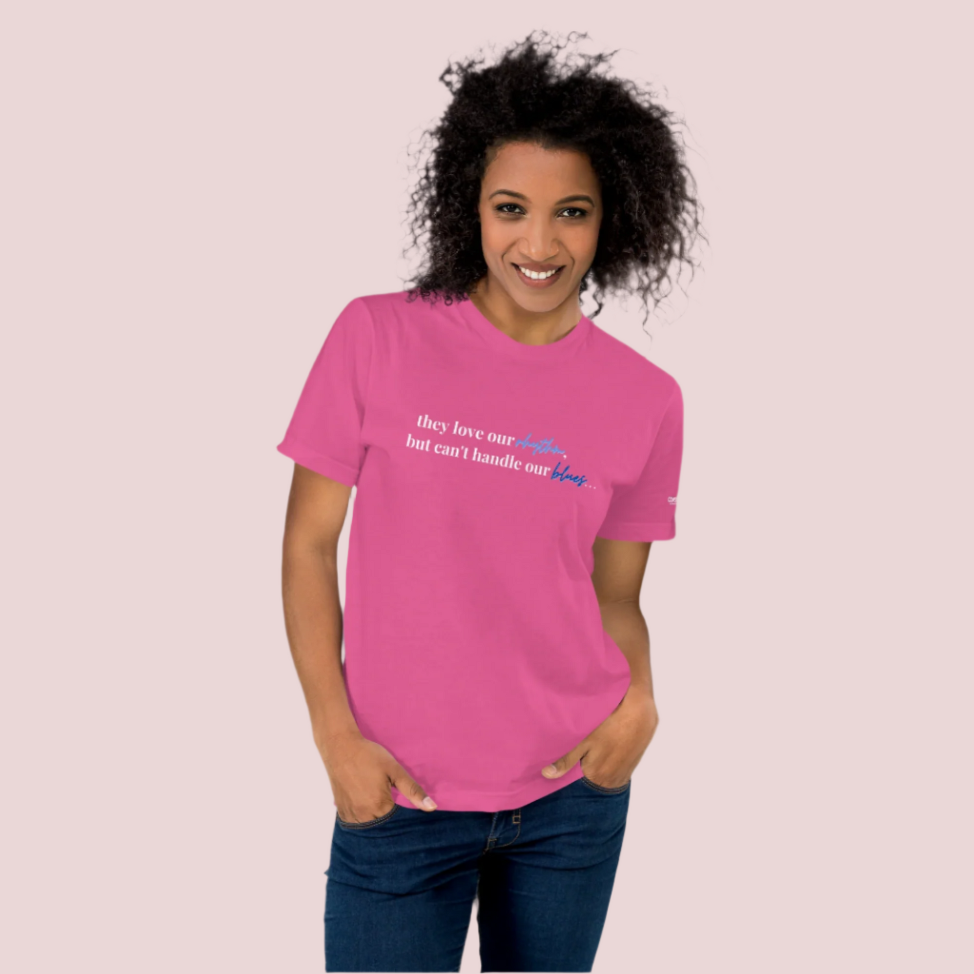 A woman wearing a hot pink t-shirt with the text "They love our rhythm, but they can't handle our blues" on the front.