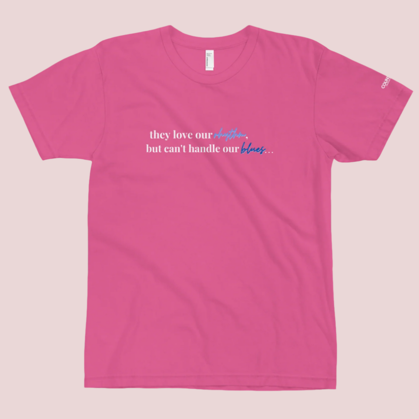 A hot pink t-shirt with the text "They love our rhythm, but they can't handle our blues" on the front.