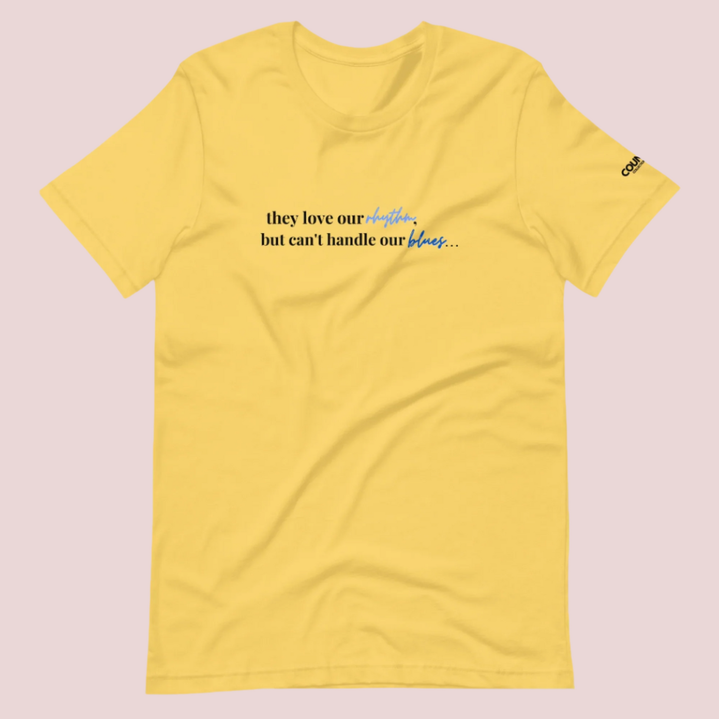 A yellow t-shirt with the text "They love our rhythm, but they can't handle our blues" on the front.