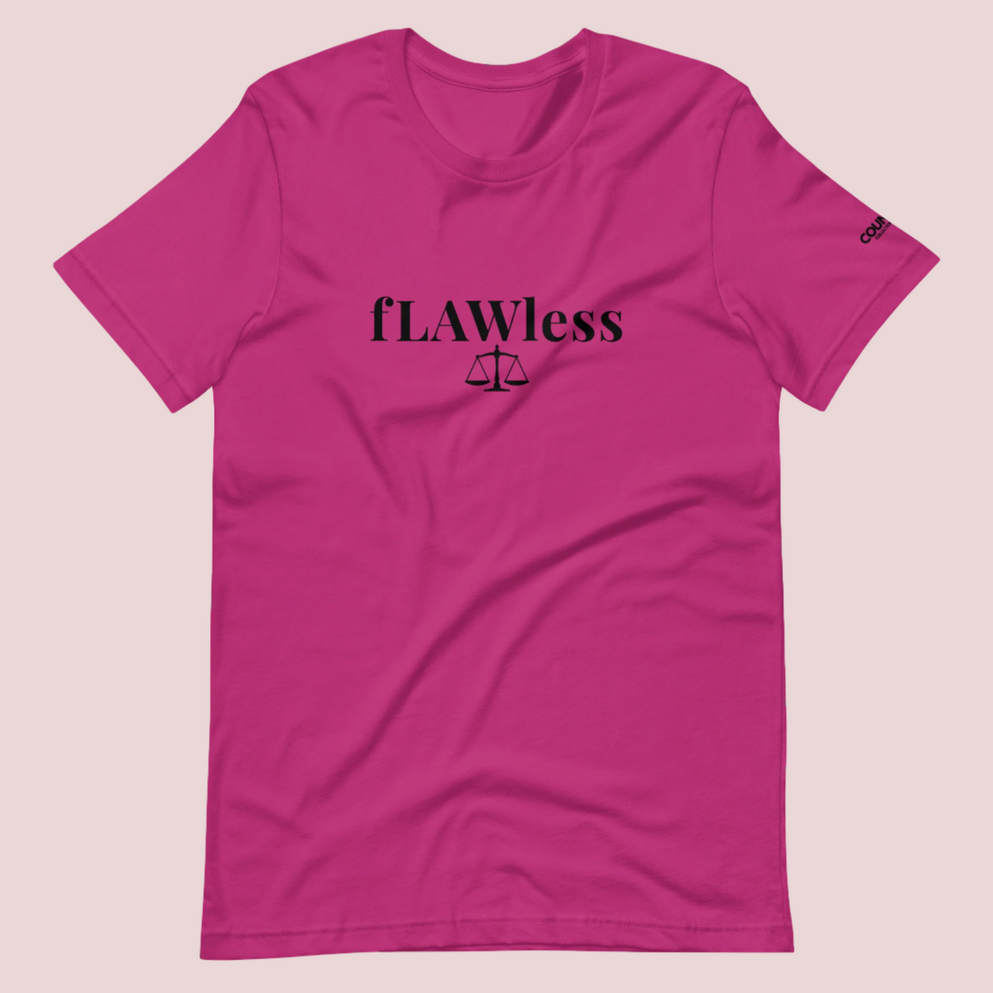 A berry roundneck tee featuring the word "fLAWless", with the letters LAW in uppercase font, with an illustration of justice scales below. The counsellecollection logo is also seen on the left sleeve.
