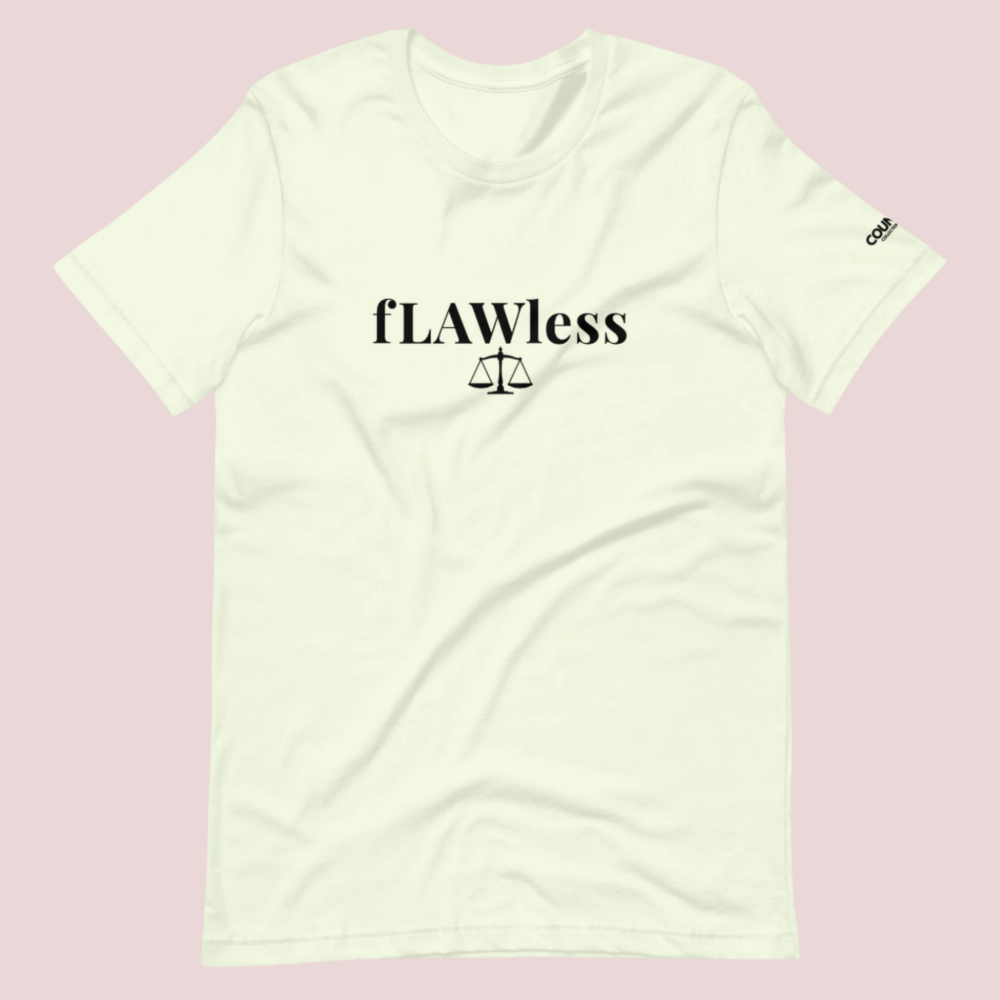A citron roundneck tee featuring the word "fLAWless", with the letters LAW in uppercase font, with an illustration of justice scales below. The counsellecollection logo is also seen on the left sleeve.™