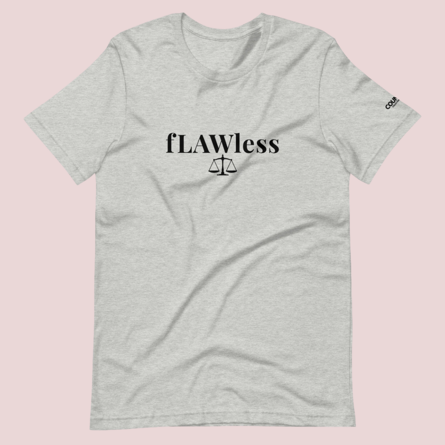 A heather grey roundneck tee featuring the word "fLAWless", with the letters LAW in uppercase font, with an illustration of justice scales below. The counsellecollection logo is also seen on the left sleeve.