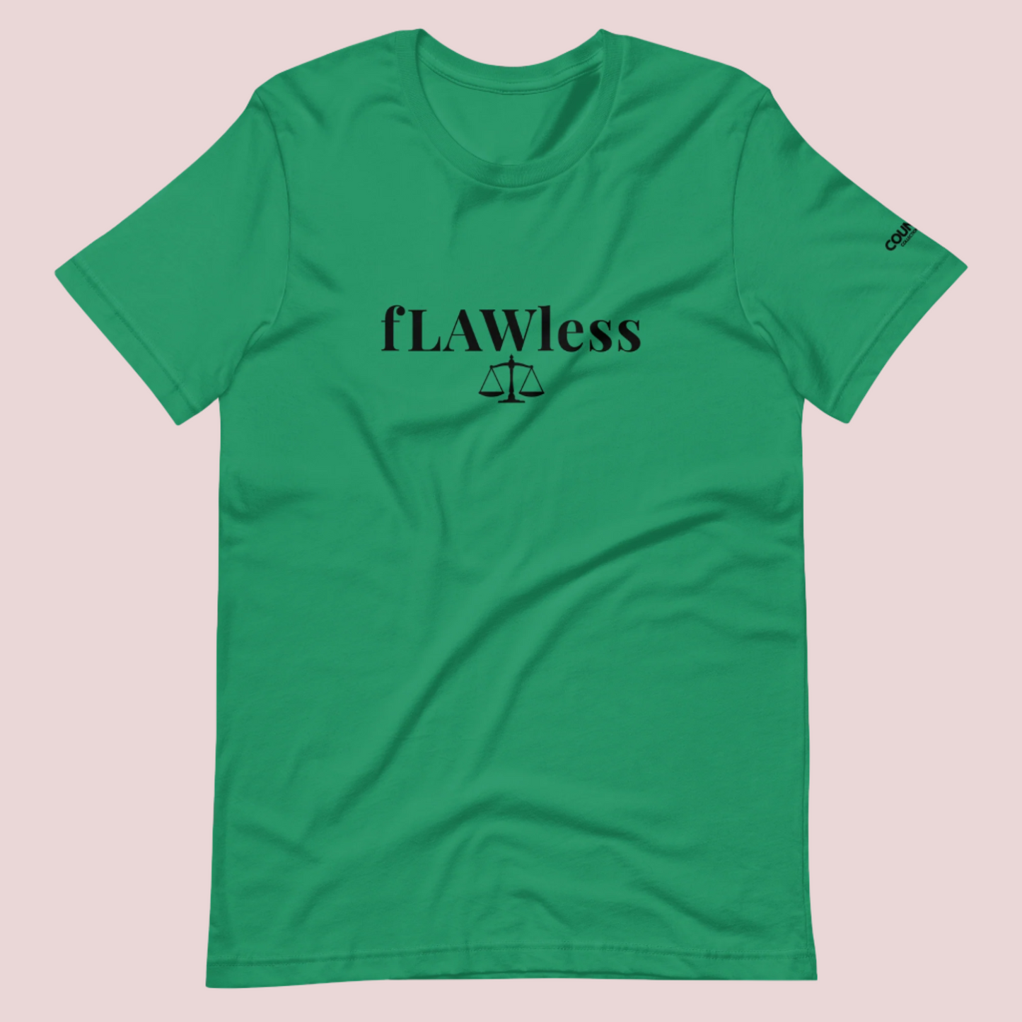 A kelly green roundneck tee featuring the word "fLAWless", with the letters LAW in uppercase font, with an illustration of justice scales below. The counsellecollection logo is also seen on the left sleeve.