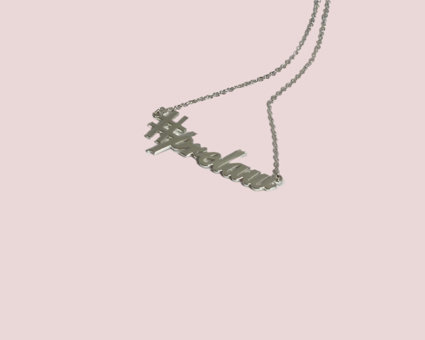 A silver chain necklace featuring the charm "#prelaw" in script font.