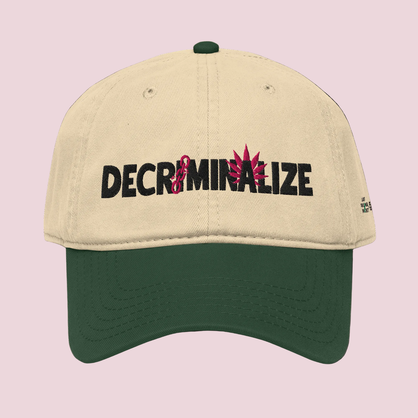 Beige and green cap with 'DECRIMINALIZE' text and cannabis leaf design on a white background